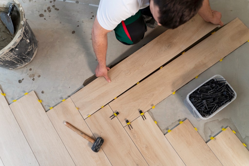 Installer laying light wood flooring