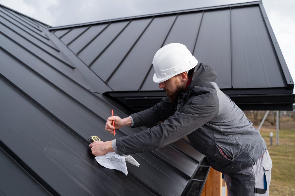 Roofer measuring a standing-seam metal roof